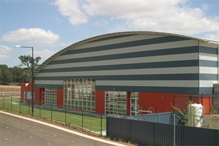 Canberra International Sports and Aquatic Centre (CISAC) is clad in spectacular stripes of LYSAGHT CUSTOM ORB® in colours Shale Grey™ and Deep Ocean®